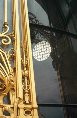 Paris - reflection of the golden door of the small palace with a circular stained glass window