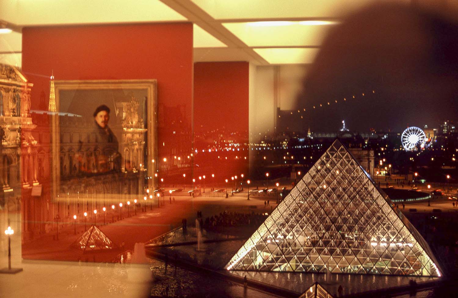 Paris - Photo taken from an interior window of the Louvre Museum one part reflects a painting from the inside and the other part the outside with the pyramid