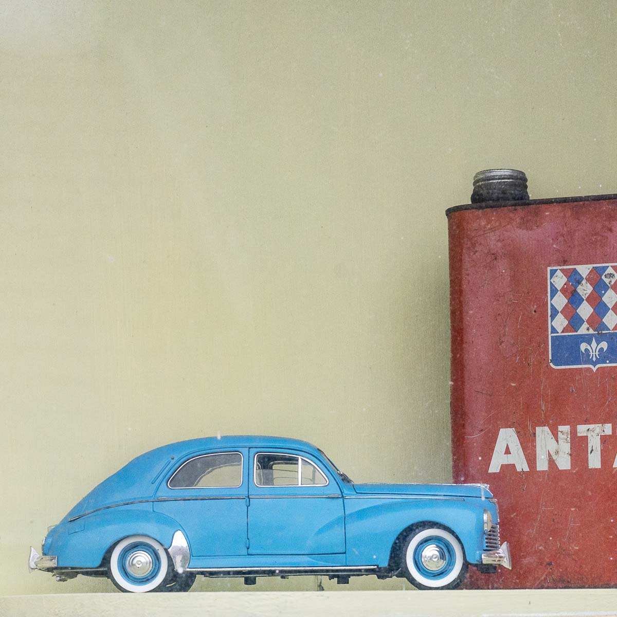 Detail in a showcase of a former garage car mechanics miniature car old collection oil can of Brand Antar in Ouzouer-le-Doyen