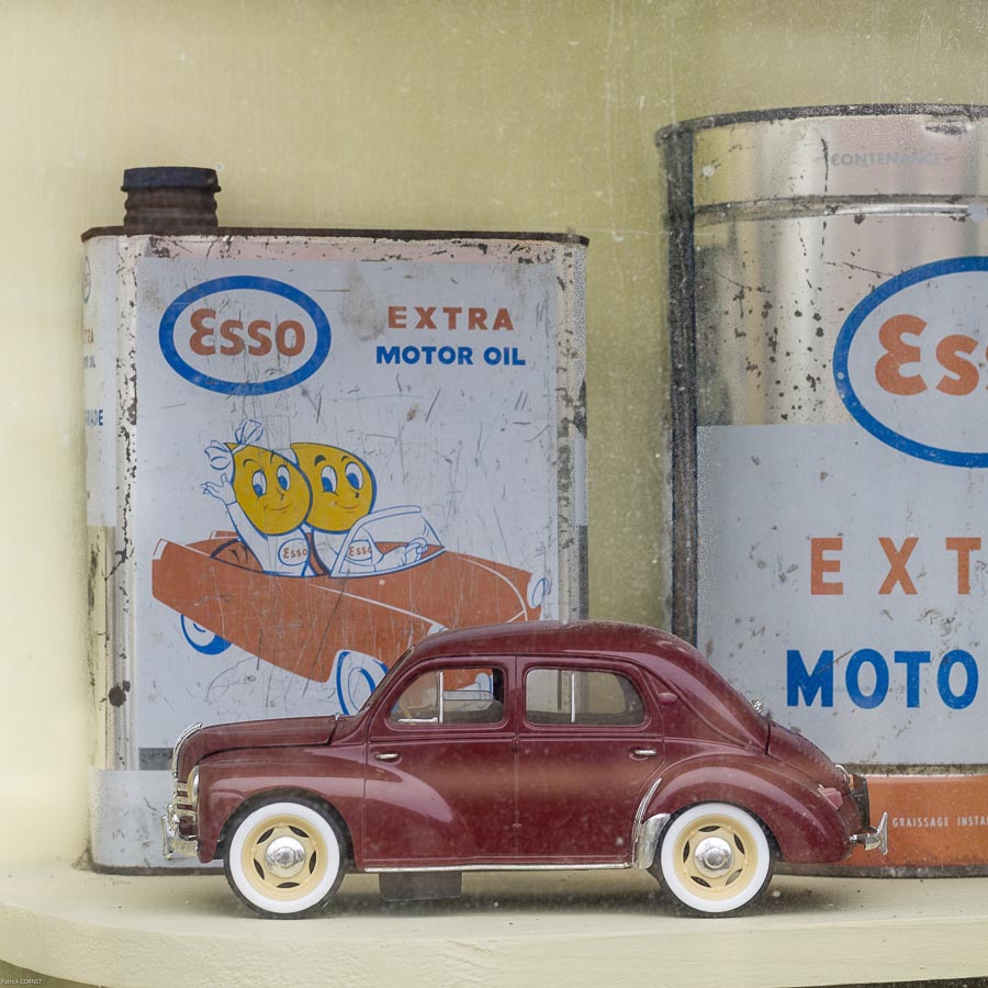 Détail dans une vitrine d'un ancien garage mécanique automobile voiture miniature ancien de collection bidon d'huile de marque Esso à Ouzouer-le-Doyen